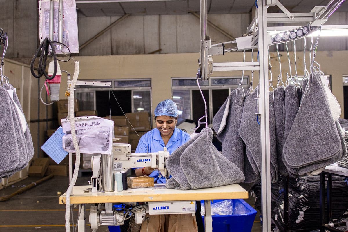 Operator sewing knit garments on the production line